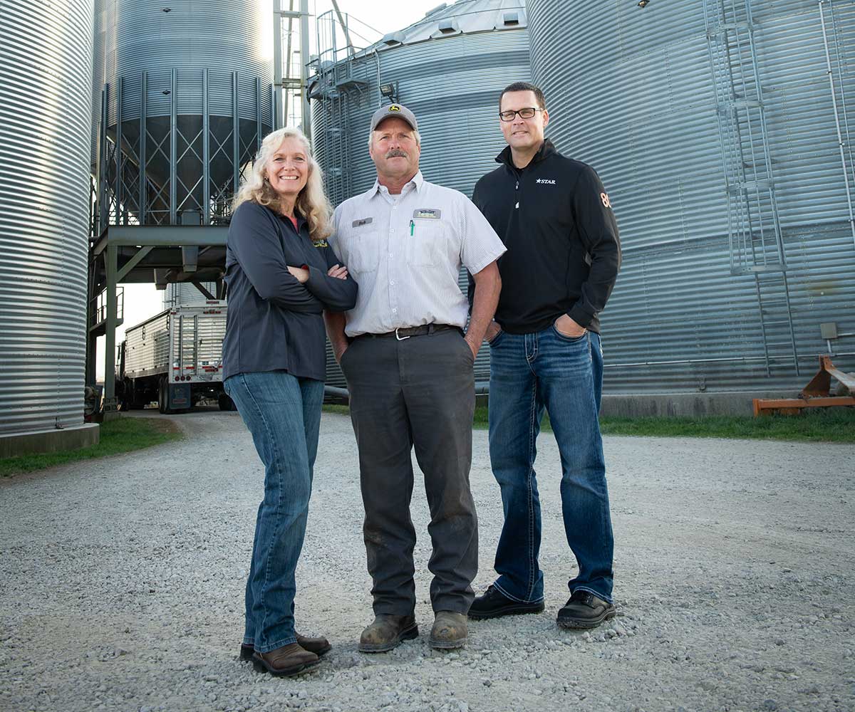 a group of people in front of farm silos