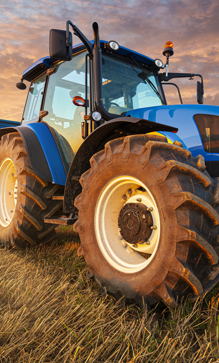 Tractor in field at sunset